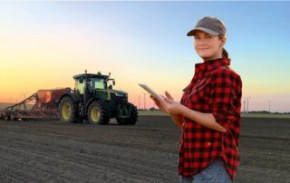 Frau mit Tablet auf einem Feld