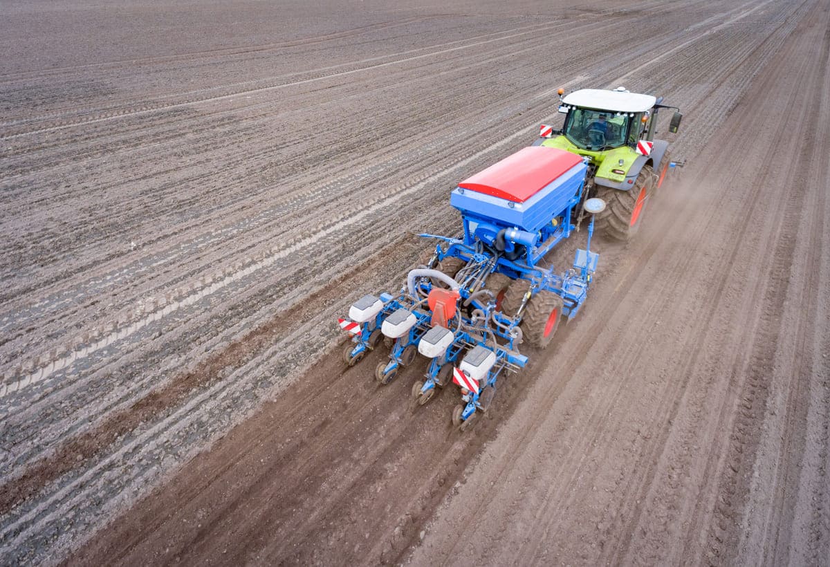 Traktor mit moderner Maislegetechnik auf dem Feld, Luftbild