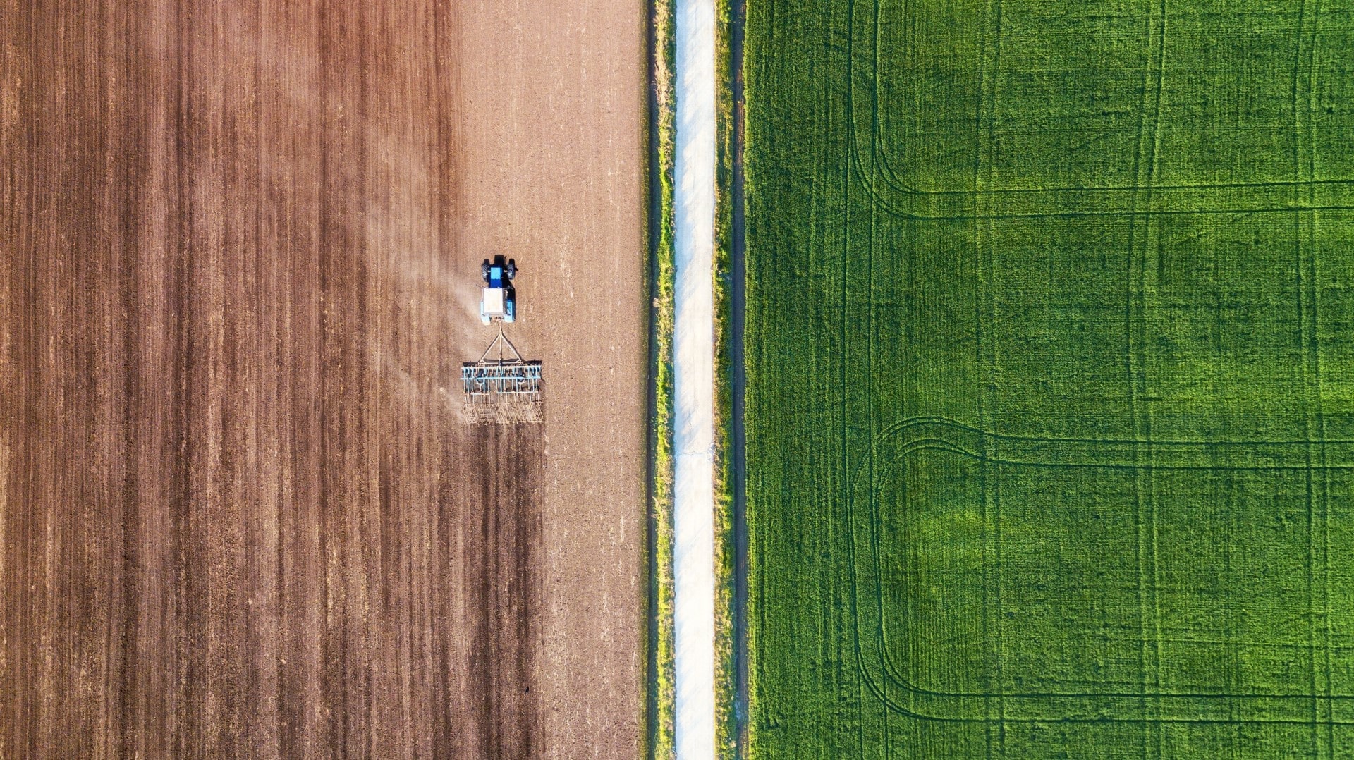 Aerial photograph of a combine harvester in a field.