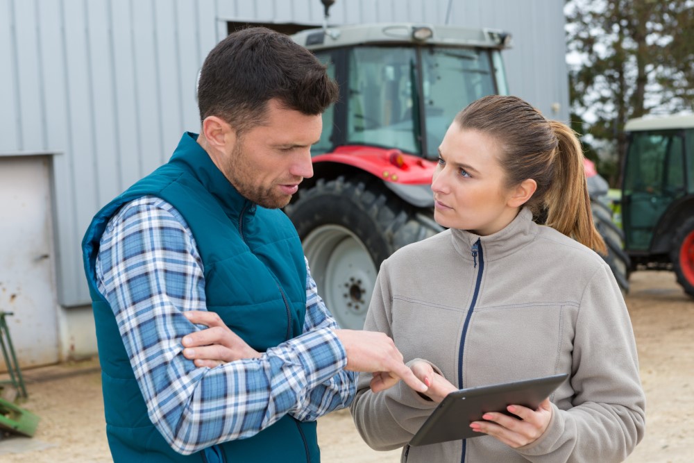 Man and woman on farm consulting a digital tablet. Man and woman on farm consulting a digital tablet.